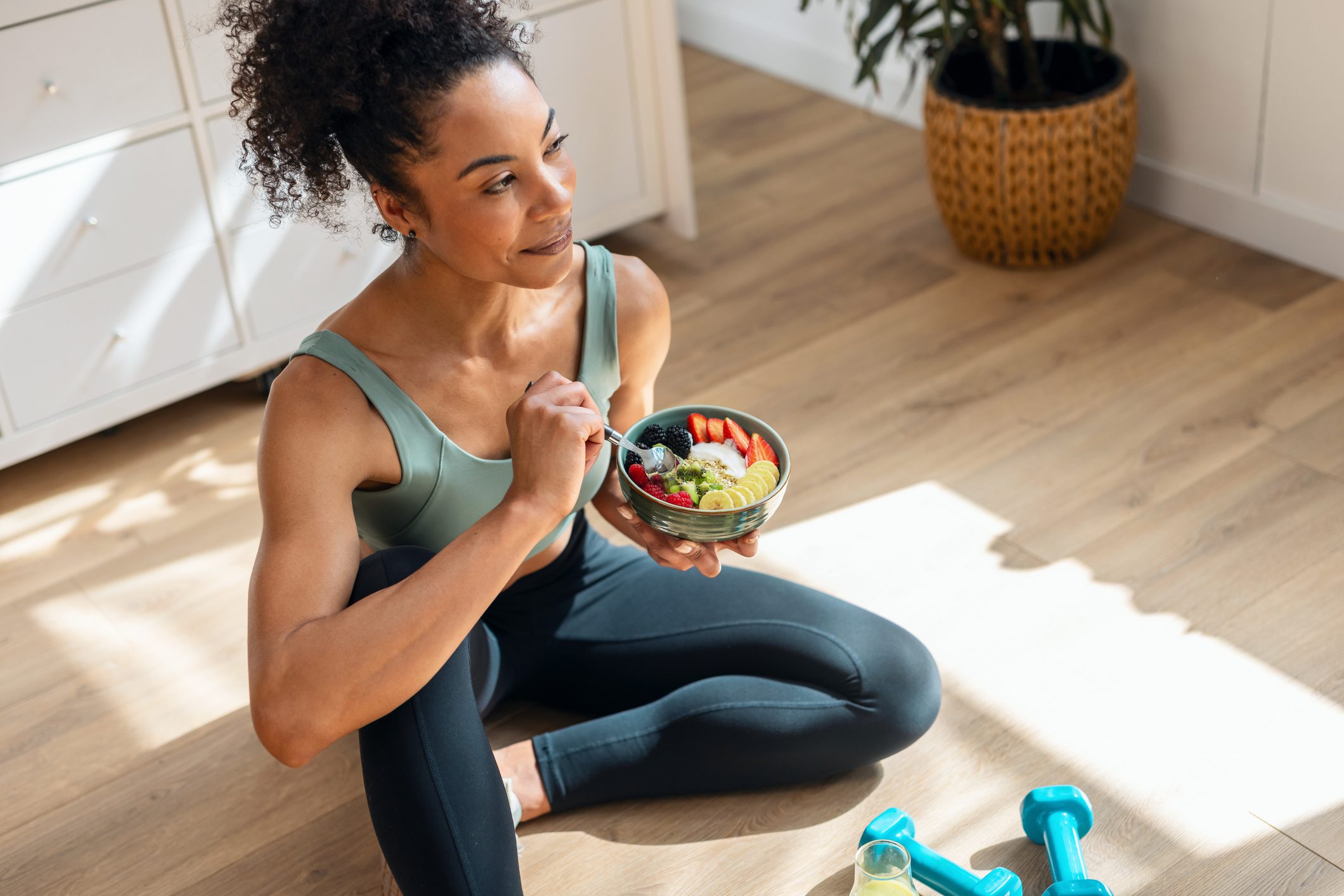 Woman eating salad after home workout.
